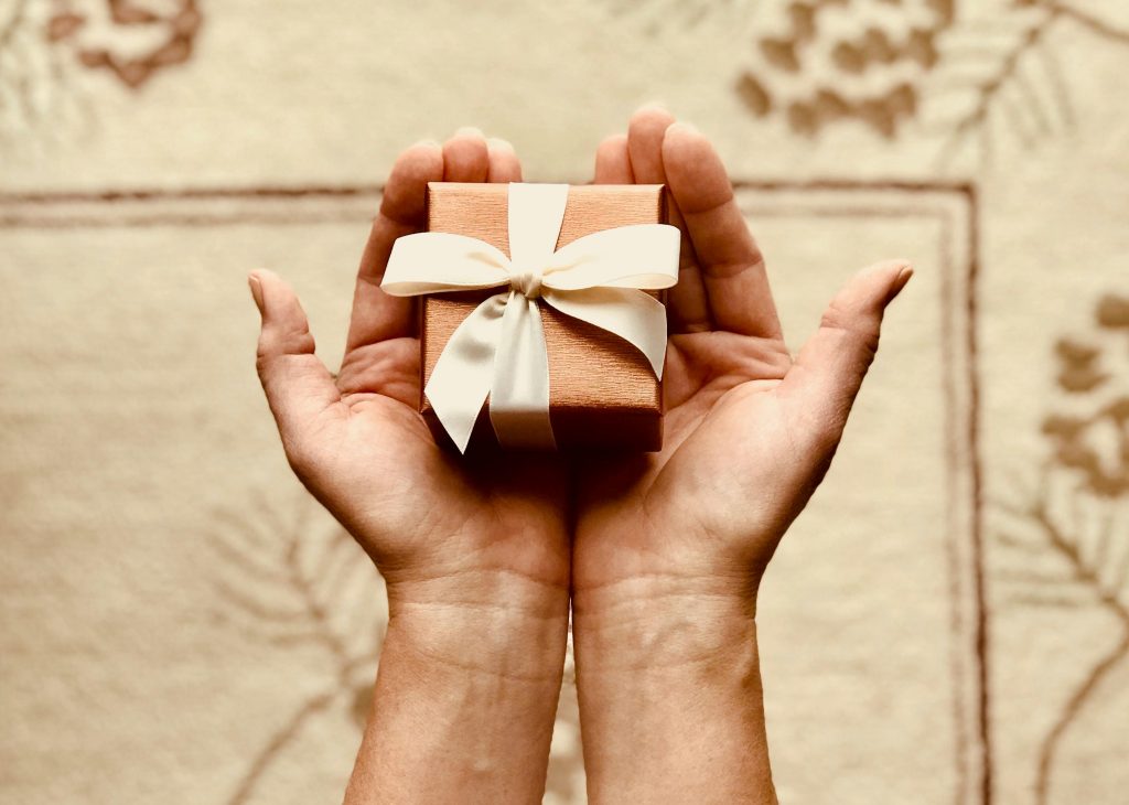 pexels-photo-842876-842876 Close-up of hands holding a beautifully wrapped gift box with a ribbon, perfect for celebrations and surprises.